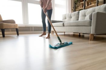 Cropped Close Up Image Of Barefoot Young Woman In Casual Clothes Washing Heated Wooden Laminate Floor