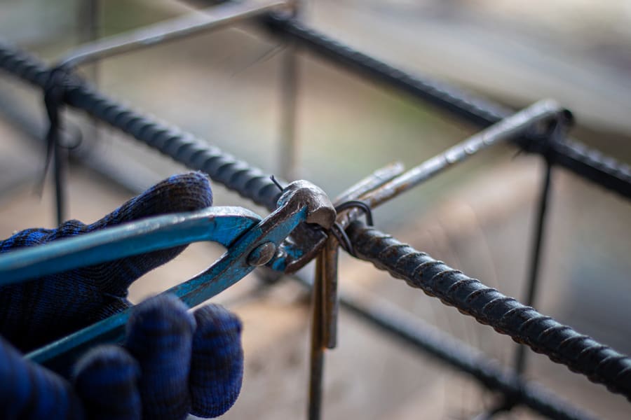 The Hands Of Construction Workers Using Using Steel Wire To Bind Steel Bars