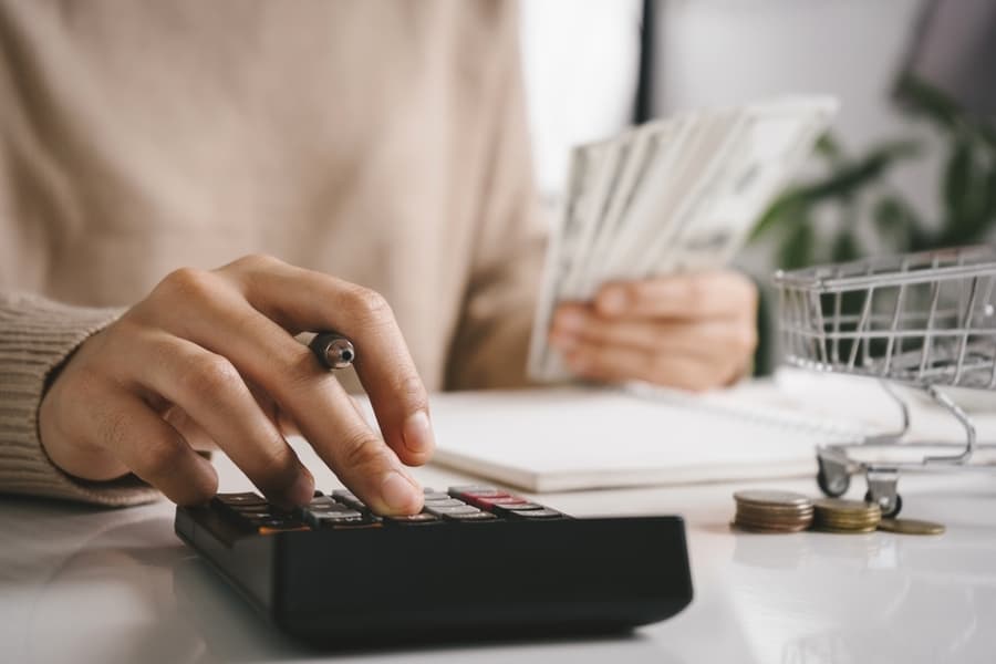 Woman Counting And Calculate Cost Money With Calculator At Home