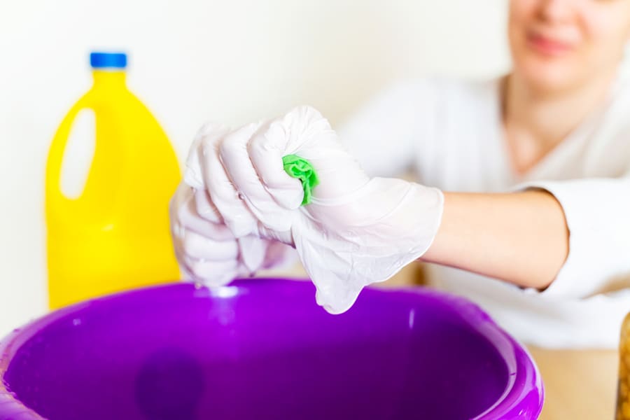 Detail Of Cleaning Lady Draining A Wipe Cloth With A Mixture Of Bleach And Water