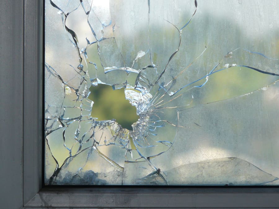 Hole In The Window Glass By A Bullet Shot During War Shooting