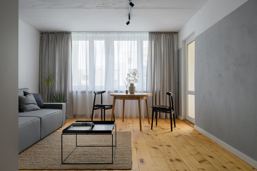 Simple Living Room With Exposed, Bare Concrete On Wall And Ceiling And Pine Wood Floor