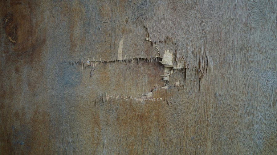 A Hole In The Thin Brown Plywood Wall