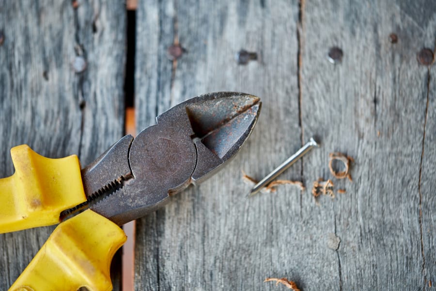 Close Up Of Yellow Pliers And Screw