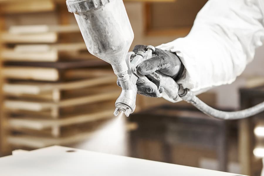 Man Spraying With Gun To The Wood.