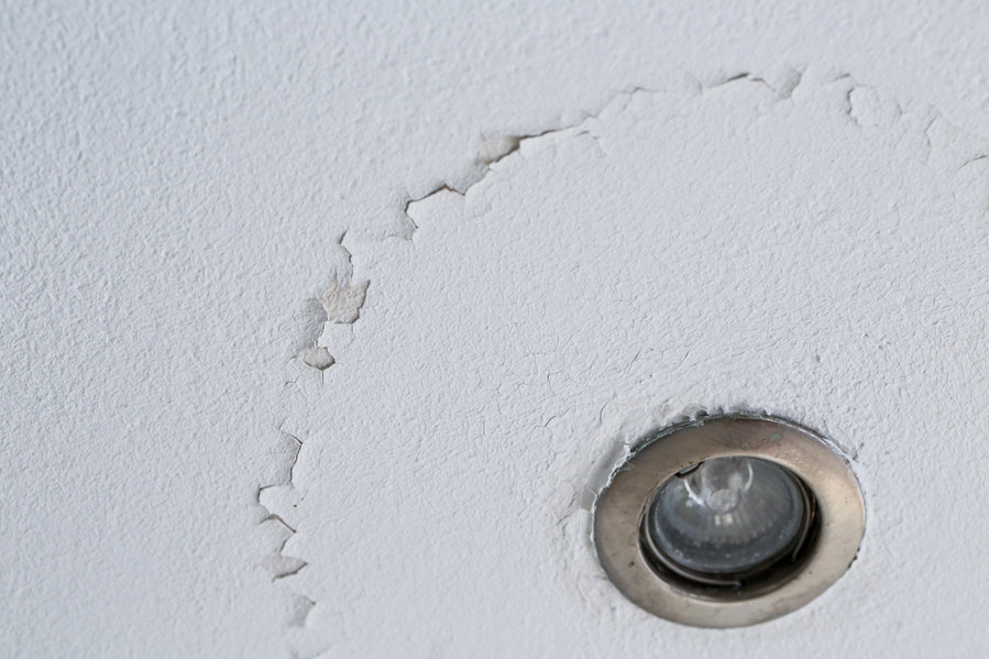 A Cracked Ceiling With Peeling Layer Due To Water Leak