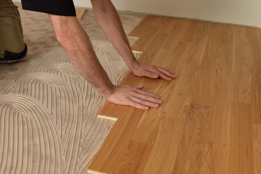 Close Up Of Worker Installing Wood Parquet