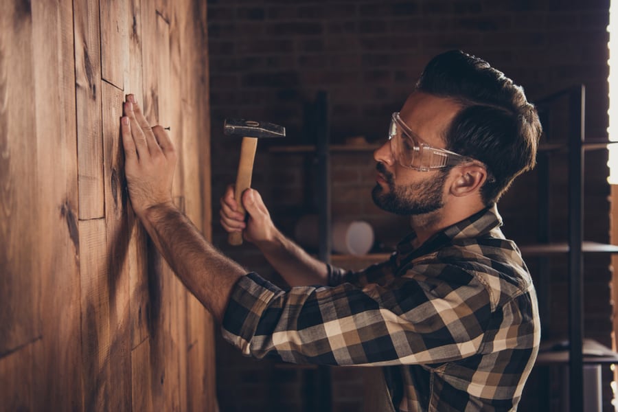 Guy Hammering Nail Into Wall