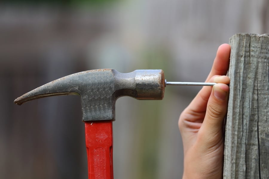 Hammer A Nail Into A Fence