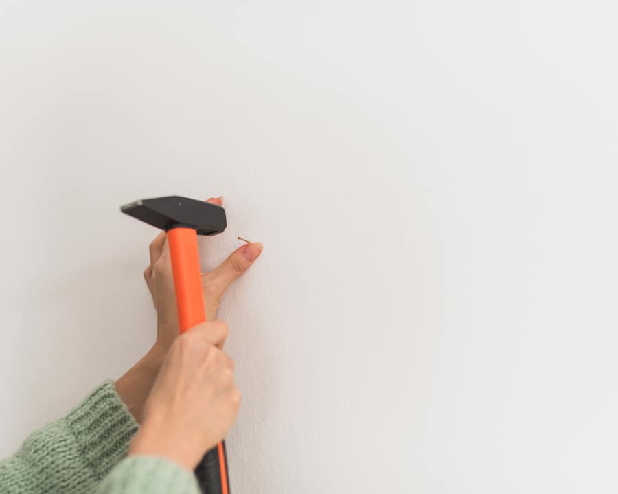 Human Hands Hammering A Nail