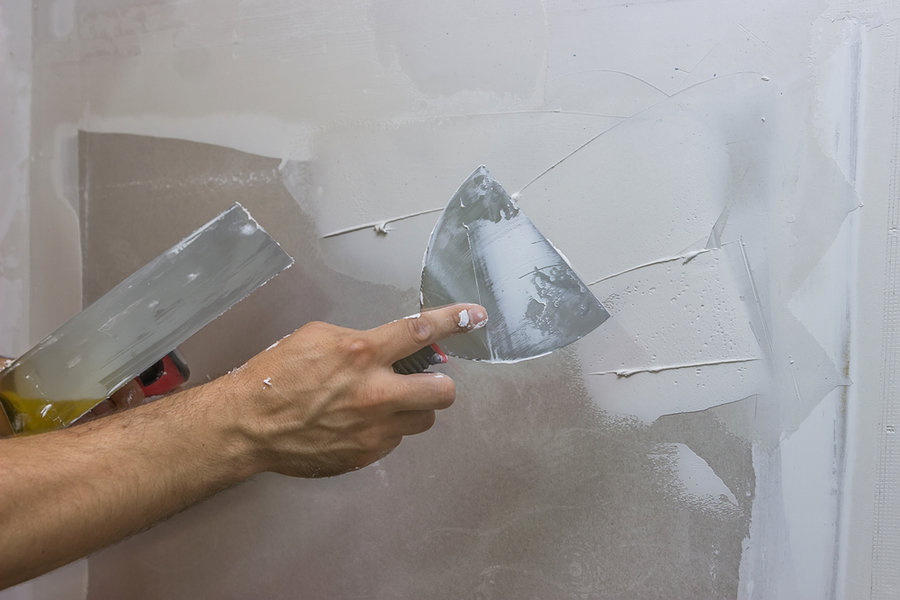 Man Hand With Trowel Plastering A Wall