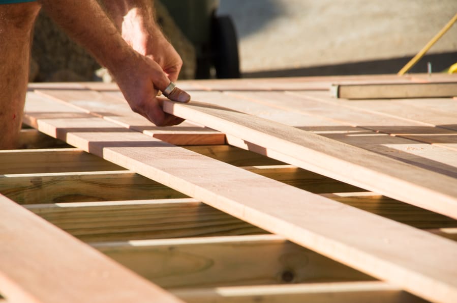 Man Placing A Plank Of Wood In A Deck