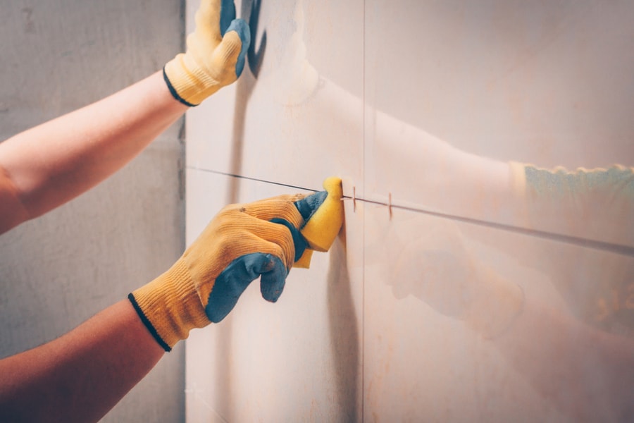 Wipes The Tile On The Wall With A Damp Sponge