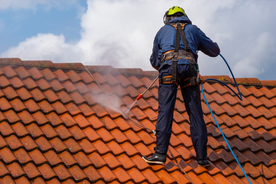 Worker Washing The Roof With Pressurized Water